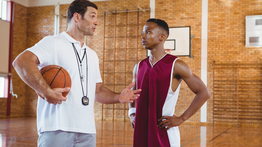 Trainer giving instructions - Youth Basketball training a basketball trainee during a basketball training session